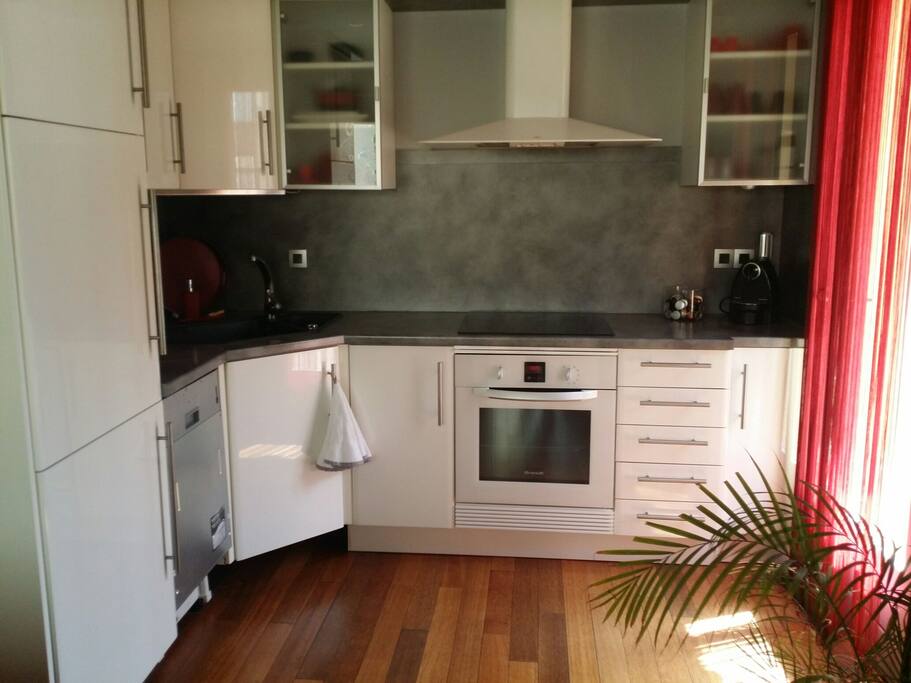 Cuisine ouverte sur le salon et accès au balcon