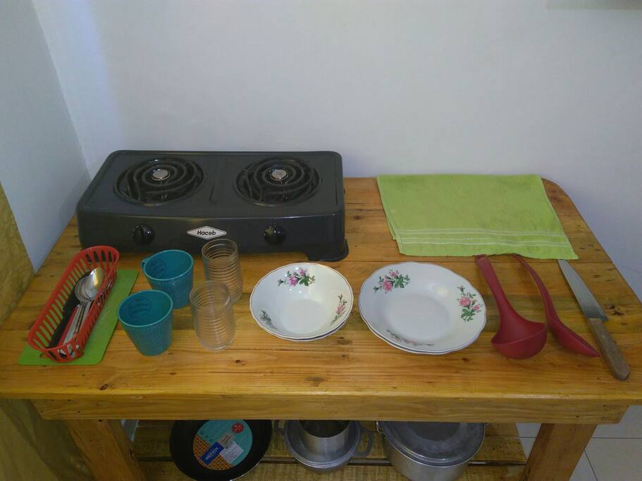 VISTA COCINA CON SUS UTENCILIOS, LOZA, CUBIERTOS, ESTUFA, OLLAS, POSILLOS, VASOS, TABLA PARA PICAR.