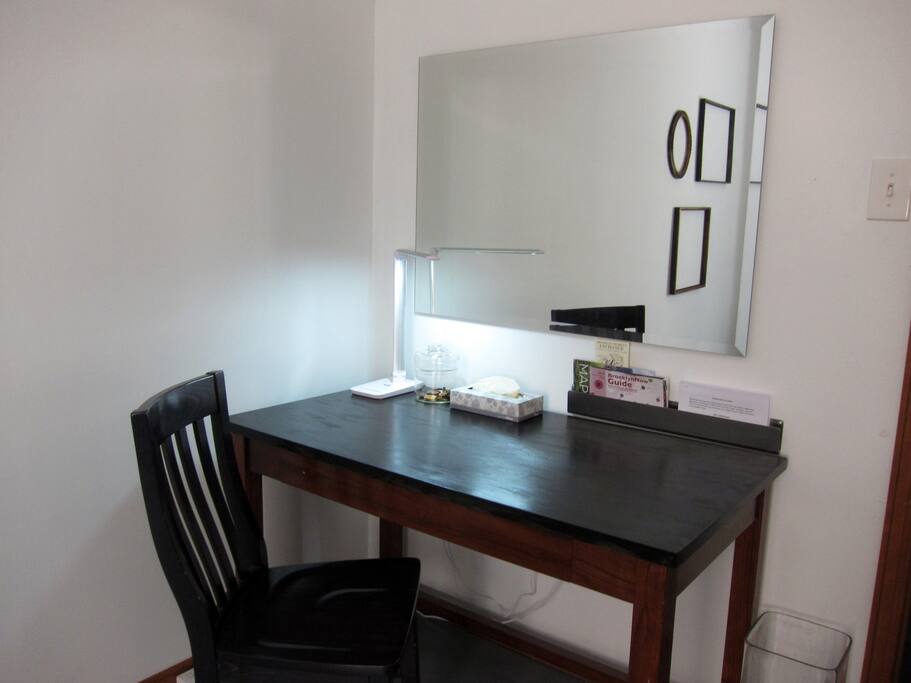 There is a nice size desk with a multi setting lamp and a huge beautiful Art Deco mirror. The desk also has a slide out drawer for laptop use. There are plug converters and USB plugs already to charge your laptop, phone, Kindle, or ipad.