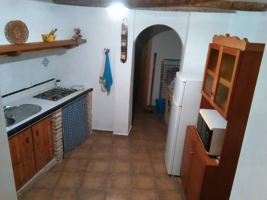 Cocina con fregadero, nevera y microondas. También hay útiles de cocina (menaje, vajilla, etc.)