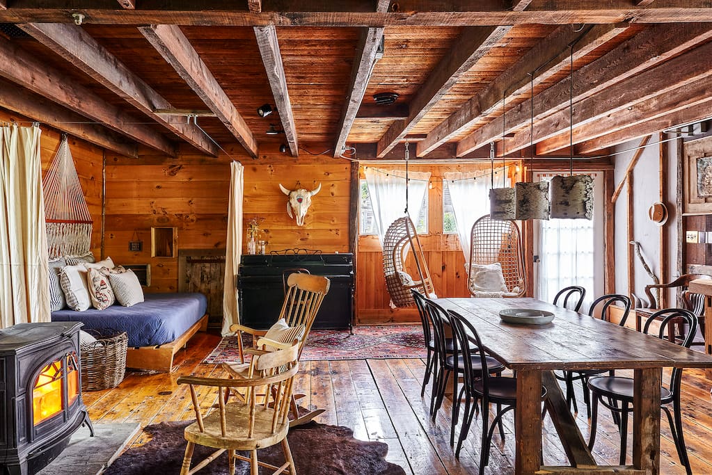 First Floor hangout // Wood burning stove, queen day bed, hanging chairs, full bathroom with rain shower, sound system , kitchen and the old rustic farm table with seating for 6.