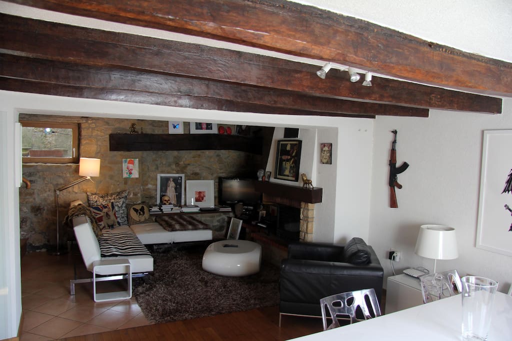 Living room with fireplace, white and stone walls, wooden floors and wood beams