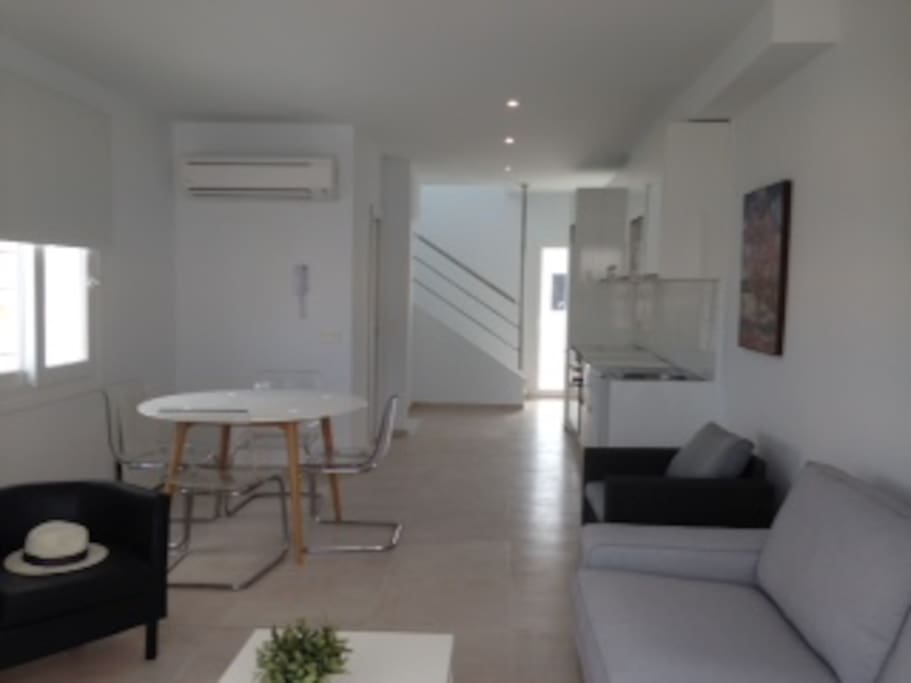 Part of lounge area showing stairs to upper levels and patio doors to the poolside