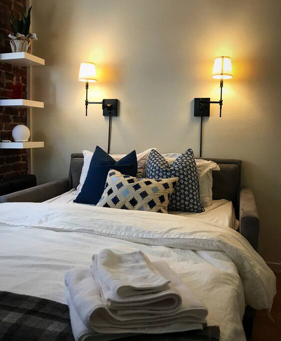 Crate & Barrel full size sleeper sofa exposing an unbelievably comfortable 4" high-density foam mattress supported on a wood platform. (Located in home office)