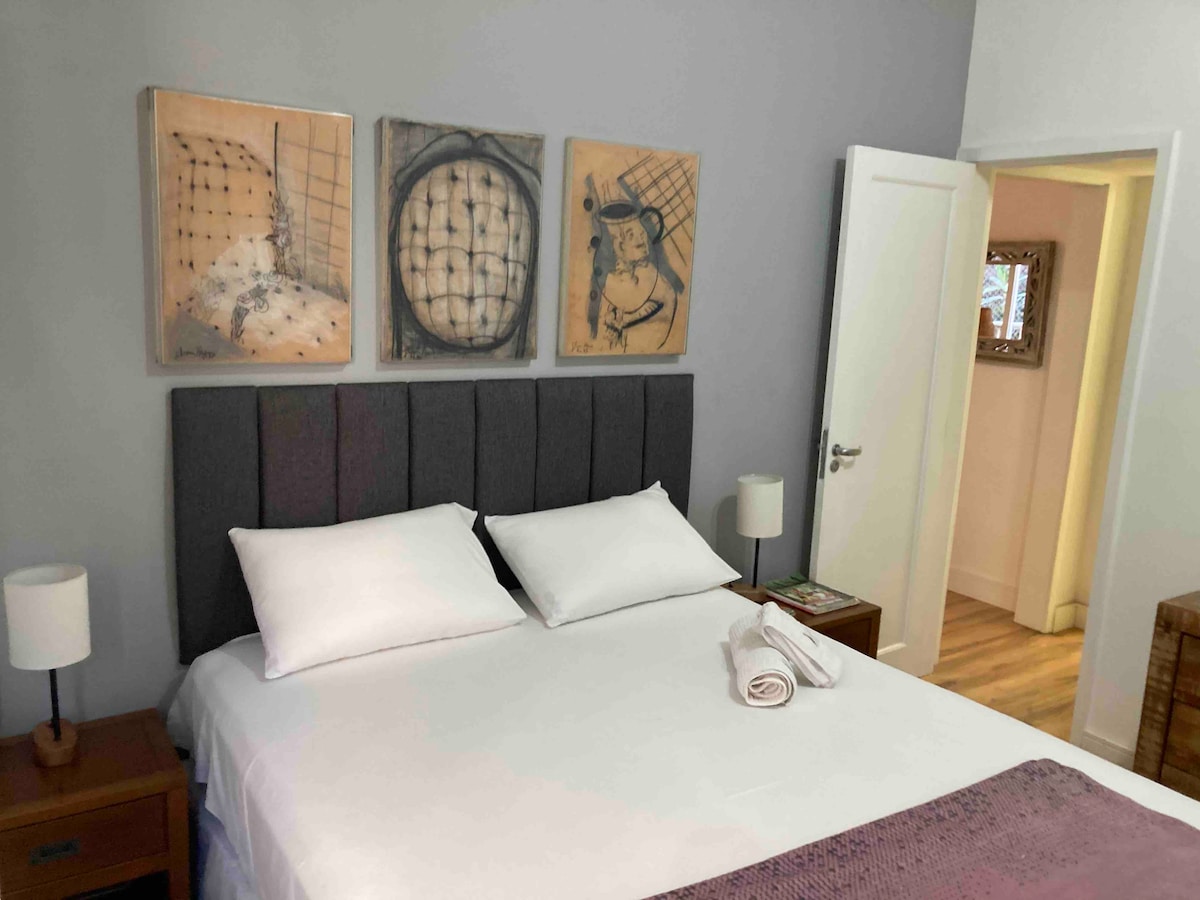 วิวห้องนอนใหญ่มีเตียงควีนไซส์และเครื่องปรับอากาศแบบแยกส่วน