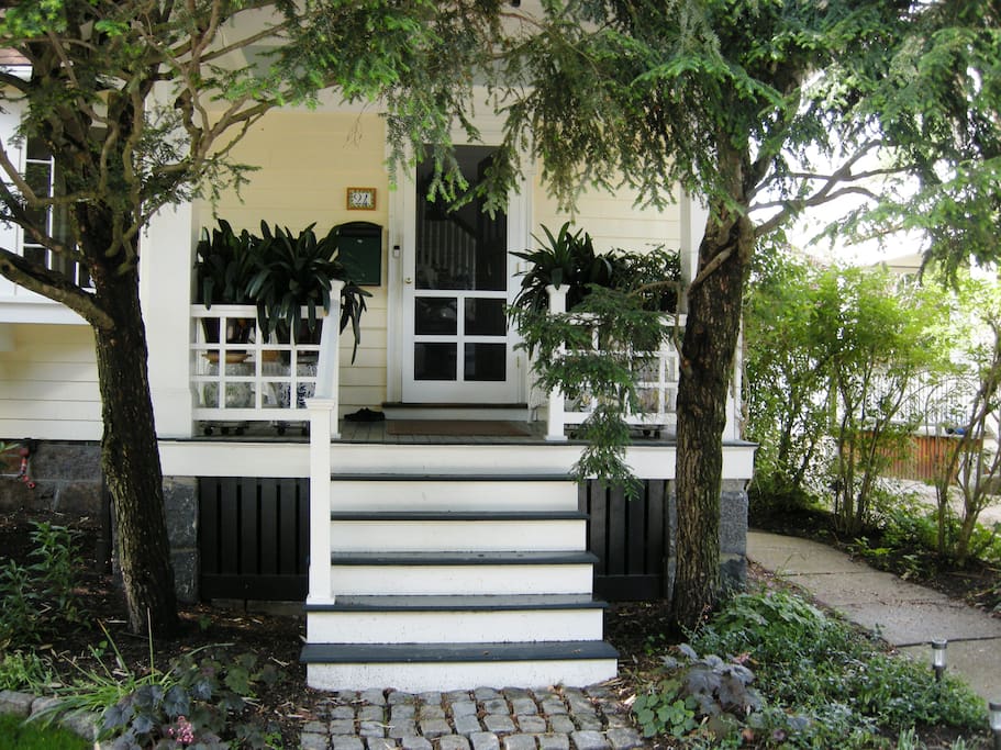 Front entrance with wrap around window pane railing.