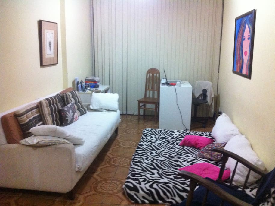 sofá cama de casal na sala e fouton de casal tem ainda dois colchões de solteiro
