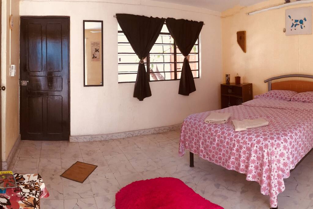 Cuarto con ventilador, cama matrimonial.