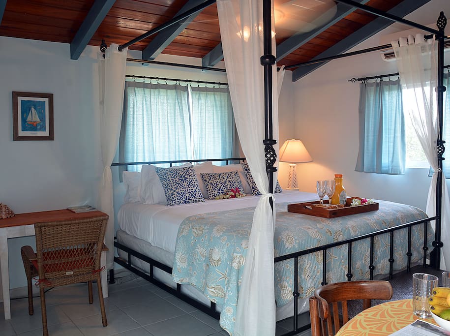 Writing desk, King poster bed, and dining table in studio villa.