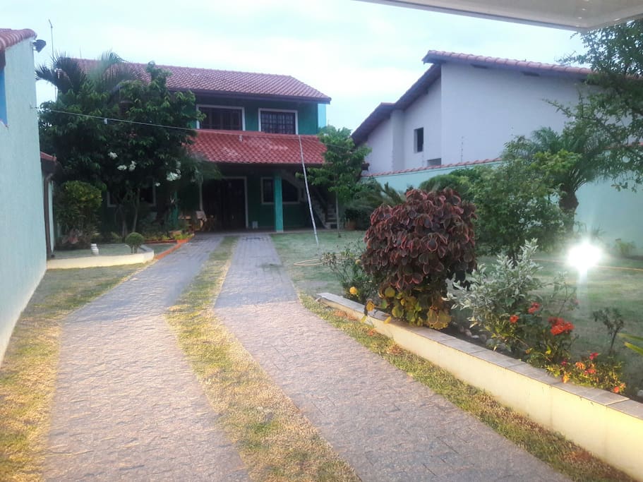 Foto da fachada principal e jardim. Entrada da garagem