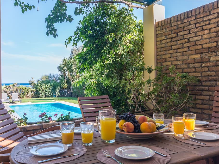 Outdoor dining on your private patio overlooking the garden, pool, and ocean