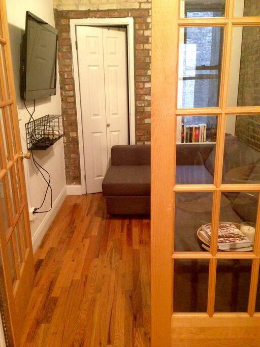 Sitting room with wall mounted television offering HBO, Netflix and Apple TV. The sofa bed easily folds out sleeping an additional 2 guests.