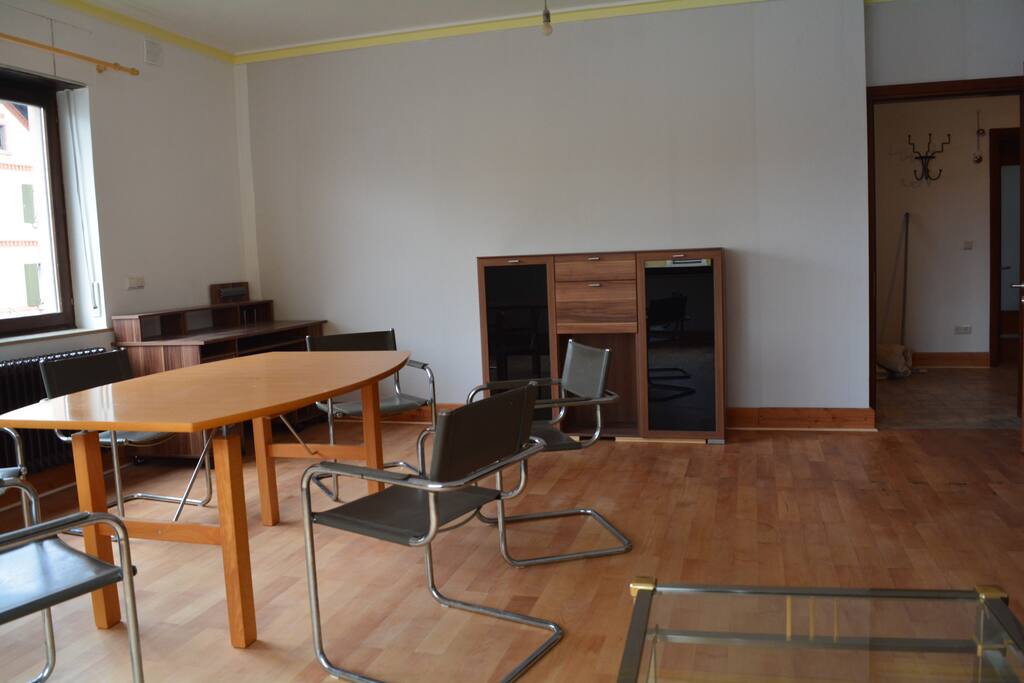 Wohn-Esszimmer mit Schreibtisch, TV und tagsüber unsichtbarem Schrankbett