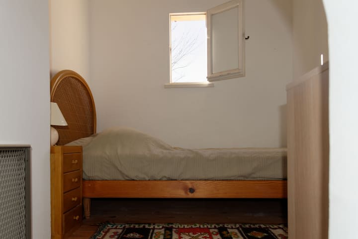 Малката спалня, до която се стига чрез стълбището, което виждаме във всекидневната. Любимото на децата. Има само едно легло на едно място (за възрастни) и влизате през малка врата (90 см), но височината на тавана е напълно нормална.