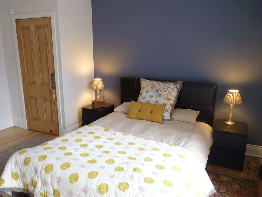 Large bright double bedroom with arm chair and double wardrobe, full length mirror and dressing table/draws