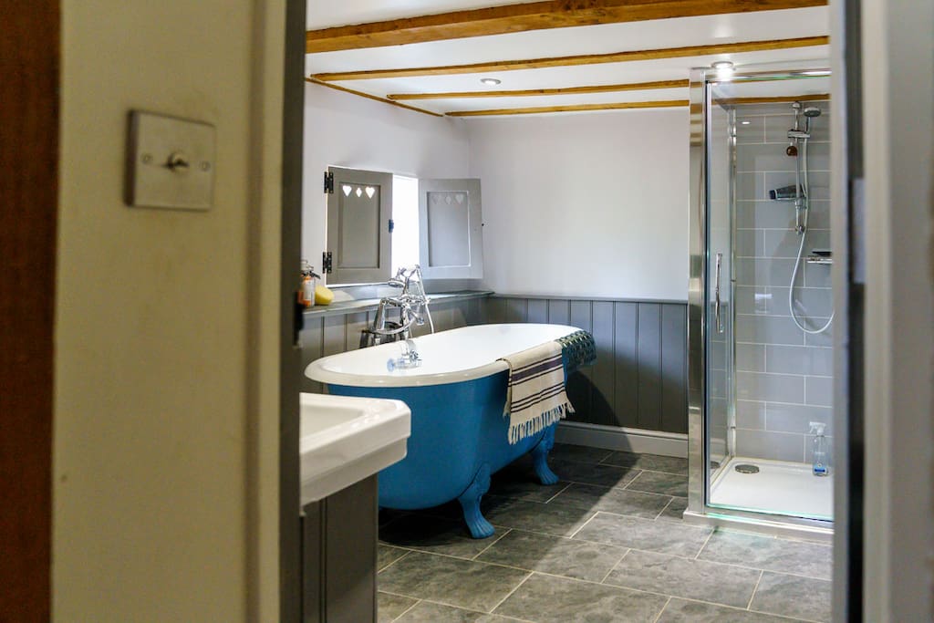 En suite bathroom with separate roll top bath and shower.