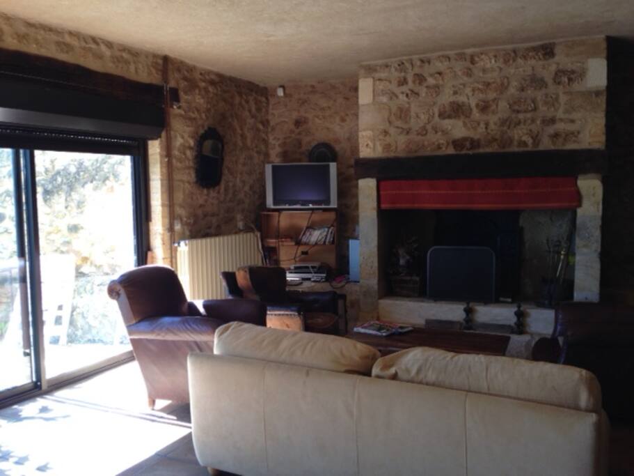 Salon cheminée avec télévision au rez de chaussée avec ouverture terrasse