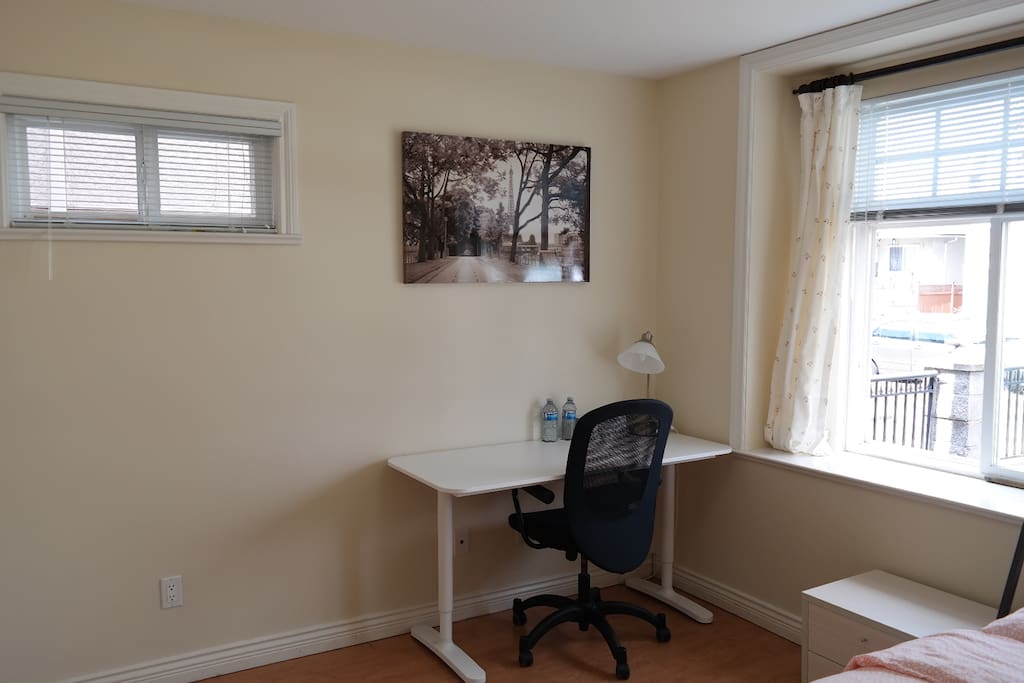 Generous desk workspace by the windows.