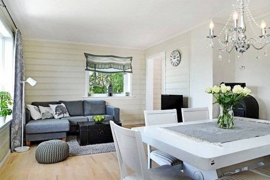 Living room wih couch, dining table with space ut to 6 people, and a fire place.
