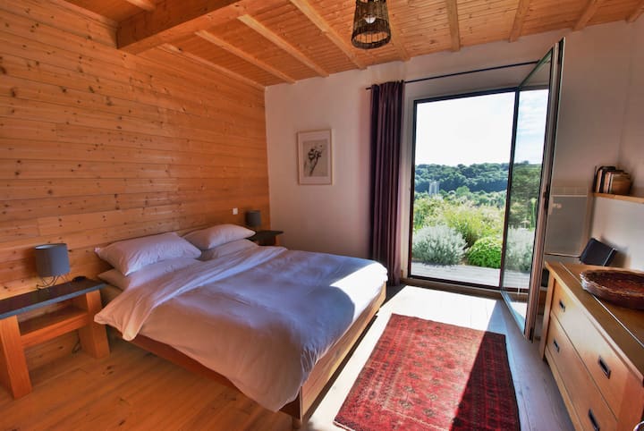 Planta baja, gran dormitorio doble principal con ropa de cama y sábanas de algodón. Vistas al mar y al valle. Acceso al jardín.
