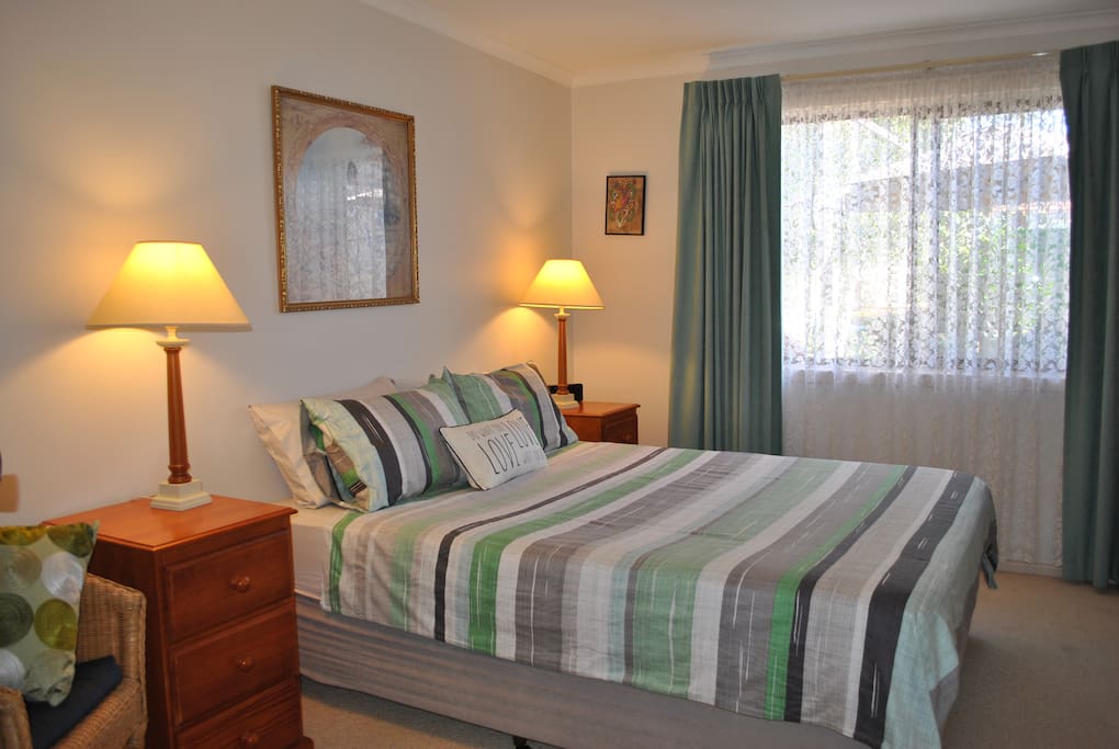 Spacious air-conditioned bedroom with built-in robe overlooking rear garden.