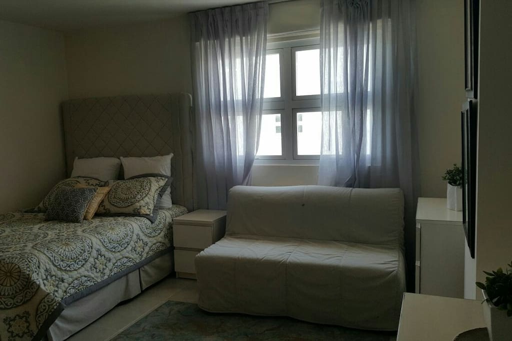 Habitación con cama doble, sofá cama para dos personas, televisor plasma, baño privado, vista lateral al.mar caribe