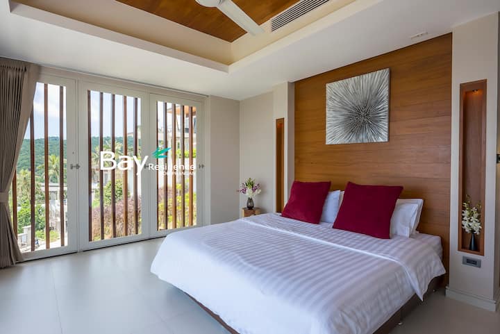 ห้องนอนที่สว่างและอบอุ่นพร้อมเครื่องนอนหรูหรา การตกแต่งด้วยไม้ และแสงธรรมชาติ เหมาะสำหรับการพักผ่อนยามค่ำคืนและตอนเช้า
