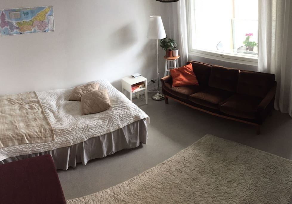 Bedroom/livingroom with comfortable queen-sized bed and view to balcony and courtyard.