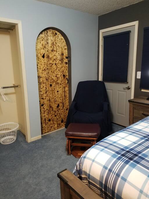 Glider chair, leather is worn so it has a sheet drapped over it. Also doorway to the balcony.