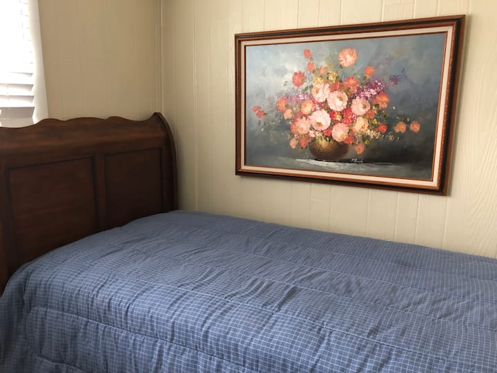 Კომფორტული ერთადგილიანი საწოლი მოსასვენებელ ოთახში, რომელიც დახურულია ფარდით. Ოთახი არის 7x11. 