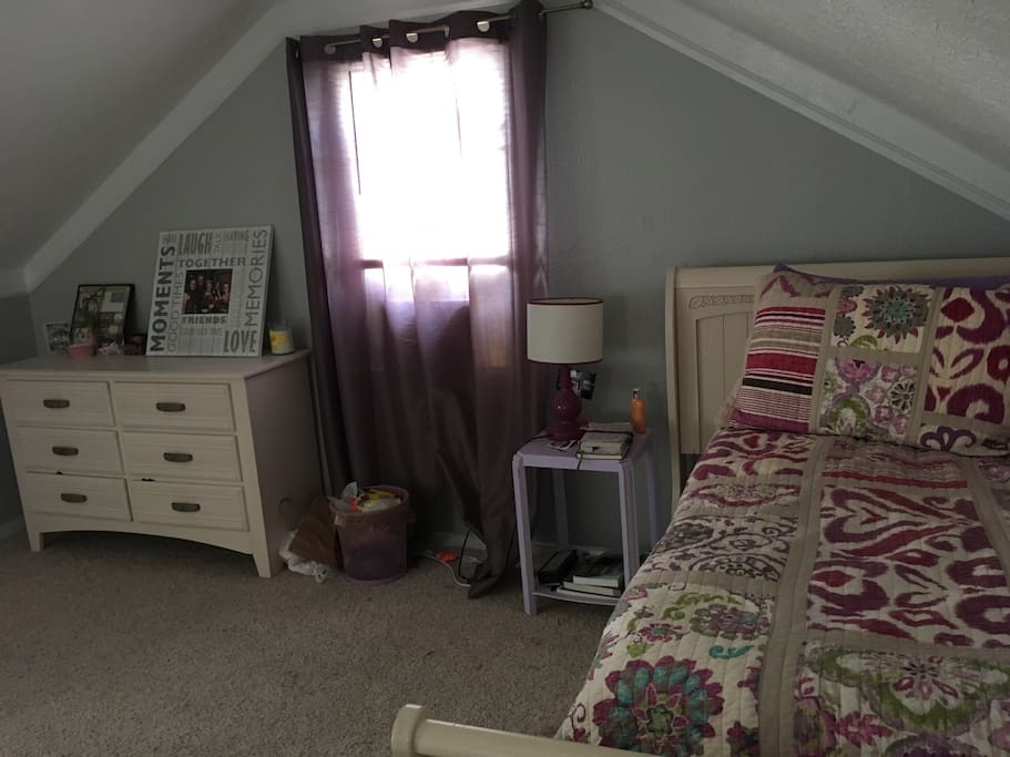 Upstairs bedroom with twin bed, and street view.