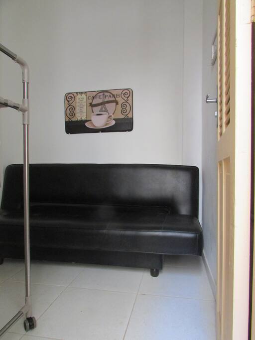 Quarto com ventilador de teto ao lado do banheiro e da cozinha