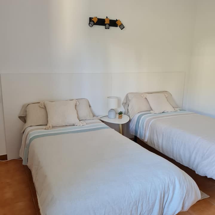 ห้องนอนที่มีเตียงแฝดขนาด 90 ซม. มองเห็นสวนที่มีต้นไม้ผลไม้