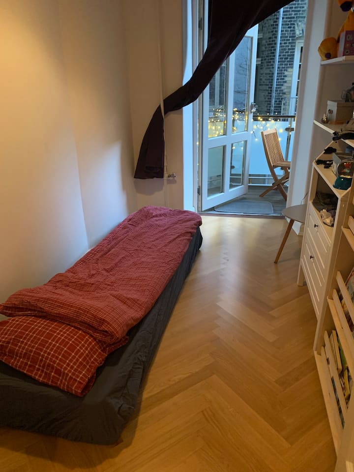 أصغر غرفة نوم مع مخرج إلى الشرفة. مرتبة قابلة للطي 80 × 190 سم.