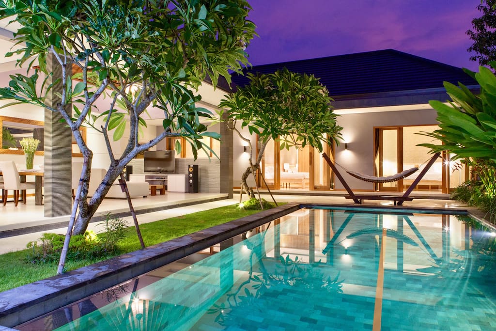 View from pool to the bedrooms and general living area at twilight.