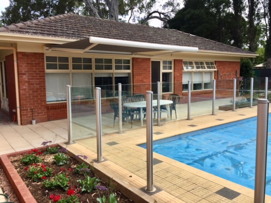 Side view of swimming pool, patio, awning and Millswood Apartment