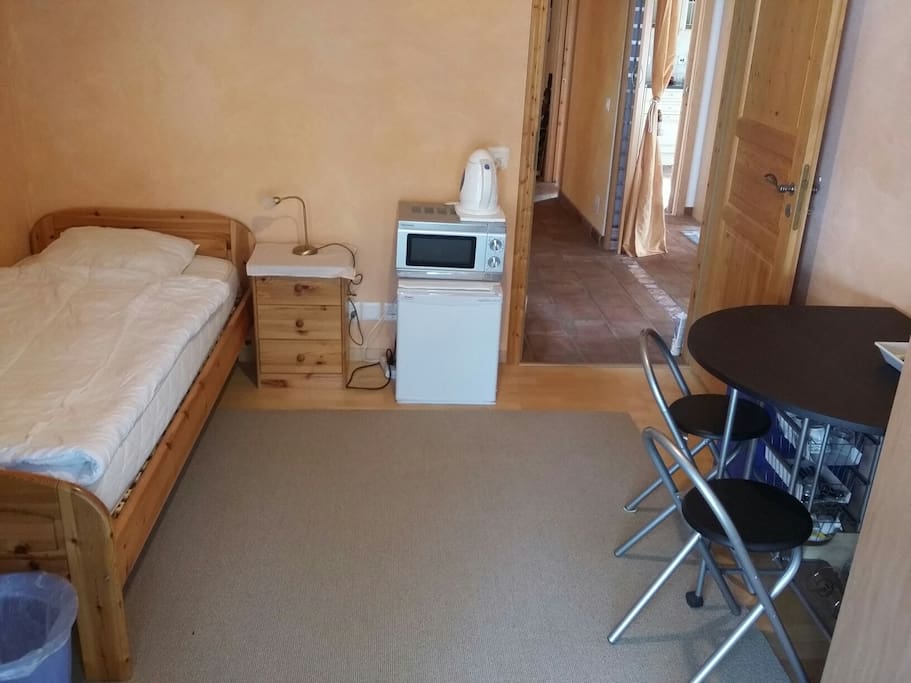 chambre avec coin à manger, vaisselle, frigo, micro-onde, chauffe-eau
