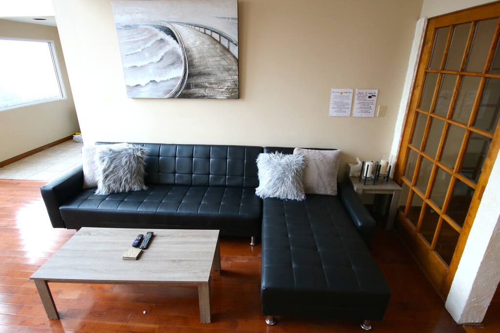 Modern Living Room: 65inch TV; RokuTV (Netflix,Skynews,etc) GoogleHome Access, Sofa Bed, 10Ft Waterview Windows