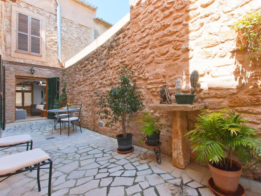 Zona de desayuno en el patio con mesa, sillas y hamacas