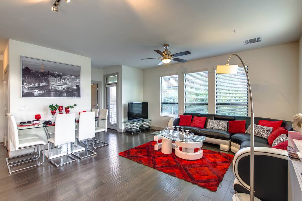 Light and spacious living room with scraped wood flooring, large windows and access to 2 private patio's.