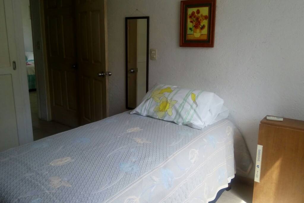 La cama individual con espejo y mesa plegable para trabajo.