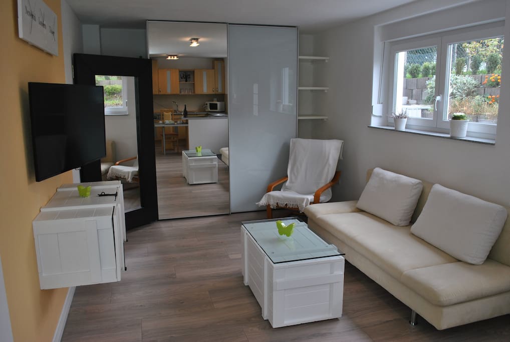Wohnzimmer mit Kleiderschrank und Schlafcouch