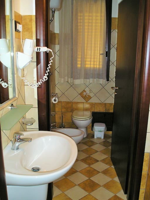 Bagno con doccia, phon e asciugamani.