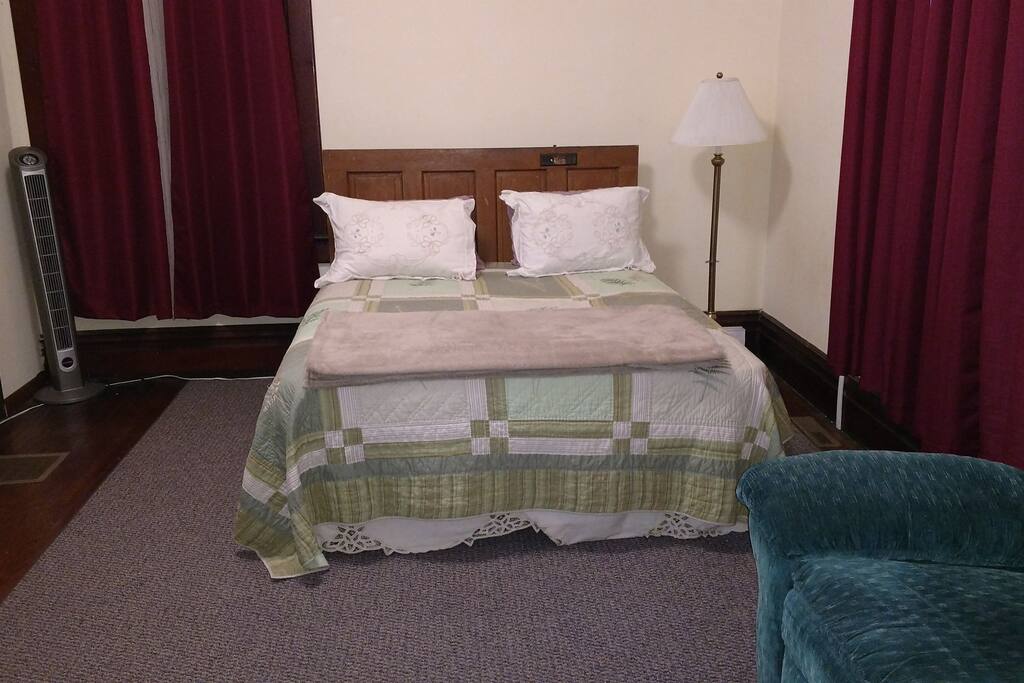Queen size bed in studio apartment.
