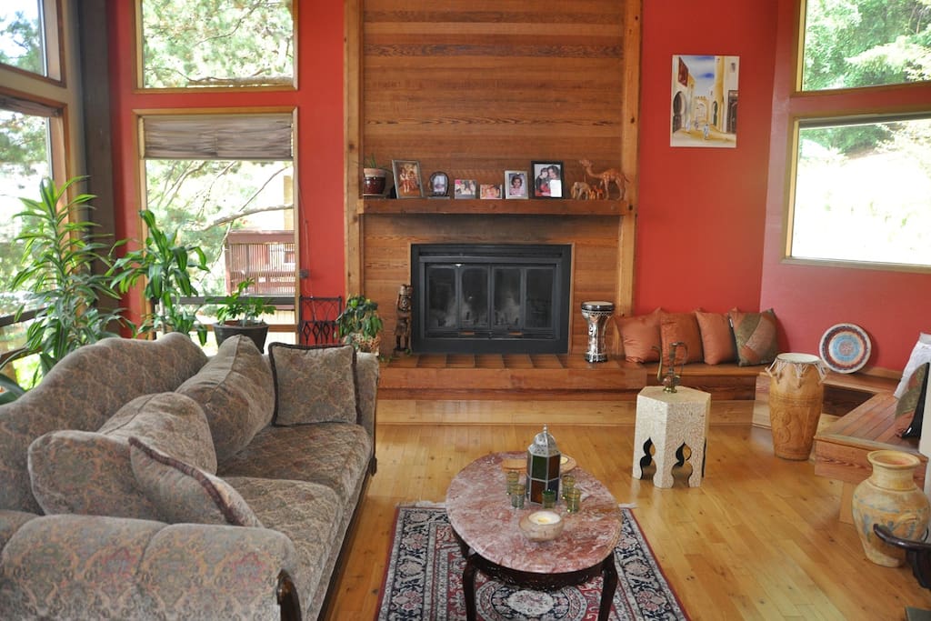 Sunny family room with cathedral ceilings, huge windows and large fireplace