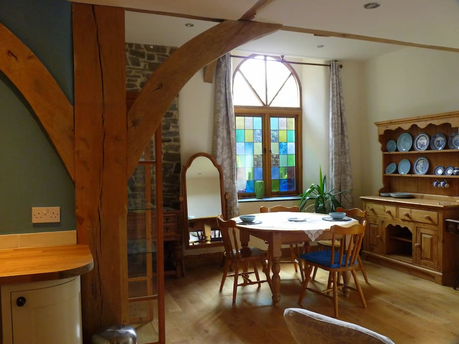 Open plan living area looking towards the chapel window with coloured leaded lights.