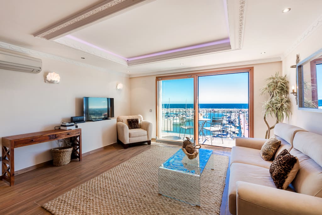 Nice living and dining room with plush sofa and great views in Puerto Banus, Marbella.Living room with flat screen TV and high speed fiber optics internet