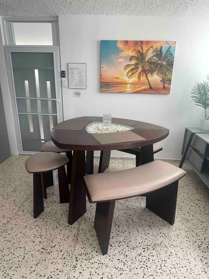 Dining table area at Tropical Enchant with beach art on the wall