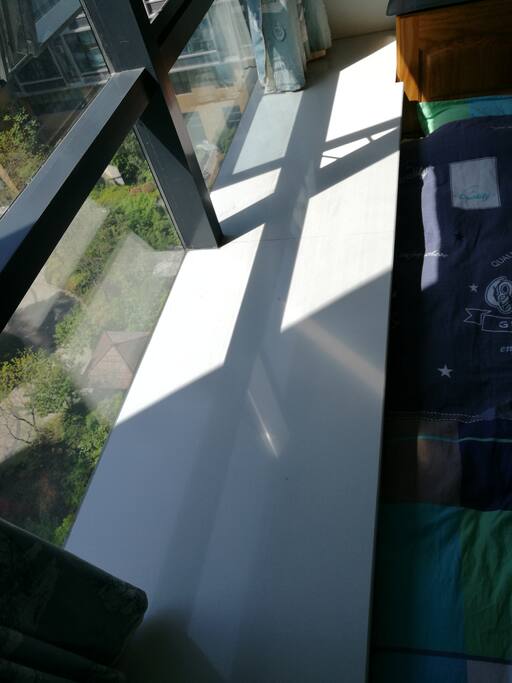A sunny bay window by the bed