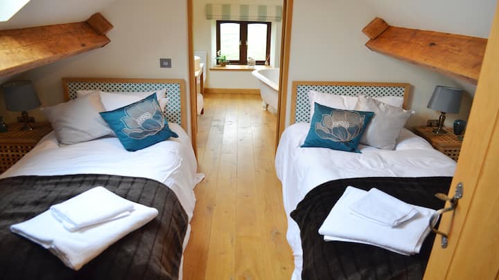 غرف بسريرين مزدوجين مع أسرّة مريحة وأغطية فاخرة.